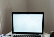 How to Track Lead Quality (Not Just Quantity)? Messy desk from above, tilted phone shot: chaotic spreadsheet on glaring screen, cold coffee rings, scattered notes, stressed 2pm vibe.