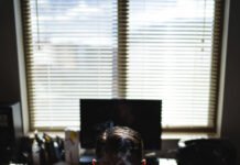 How to Optimize Content for Voice Search? Tired worker slumps in chair with rising coffee steam and messy desk.